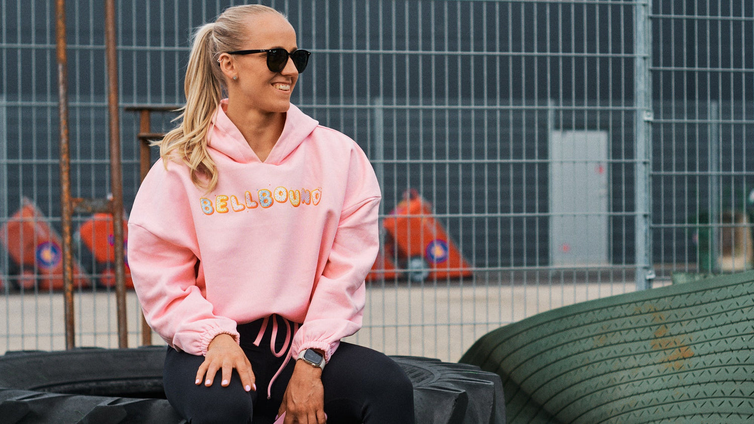 Person wearing a pink Bellbound hoodie in an industrial setting